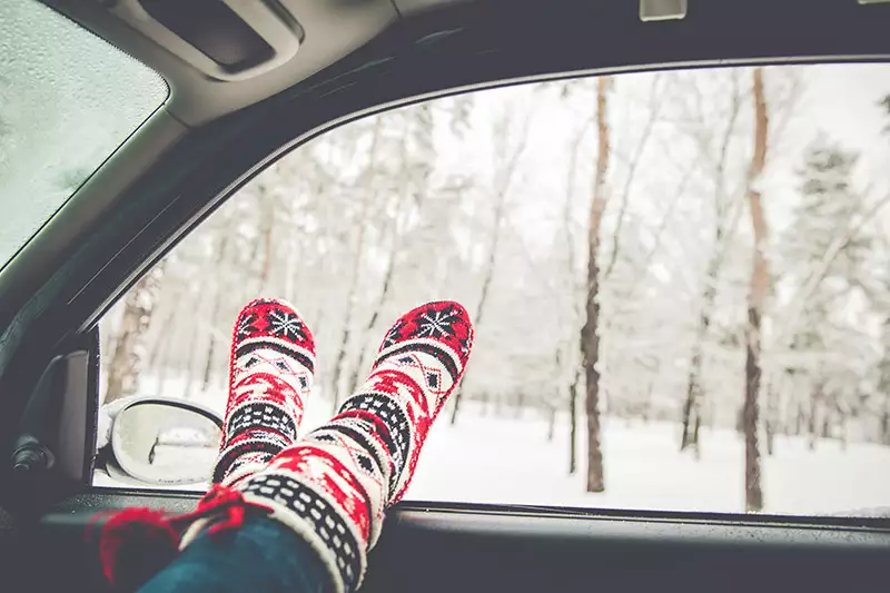Holiday socks leaning on window with wintery forest outside