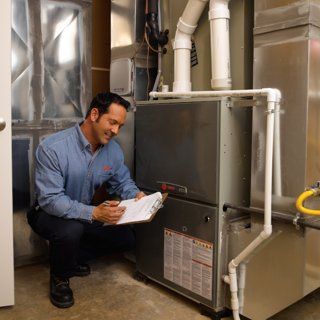 Certified Trane employee inspecting a furnace